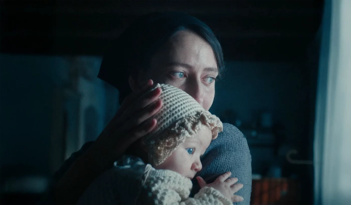 Una delle protagoniste tiene in braccio e stringe la figlia