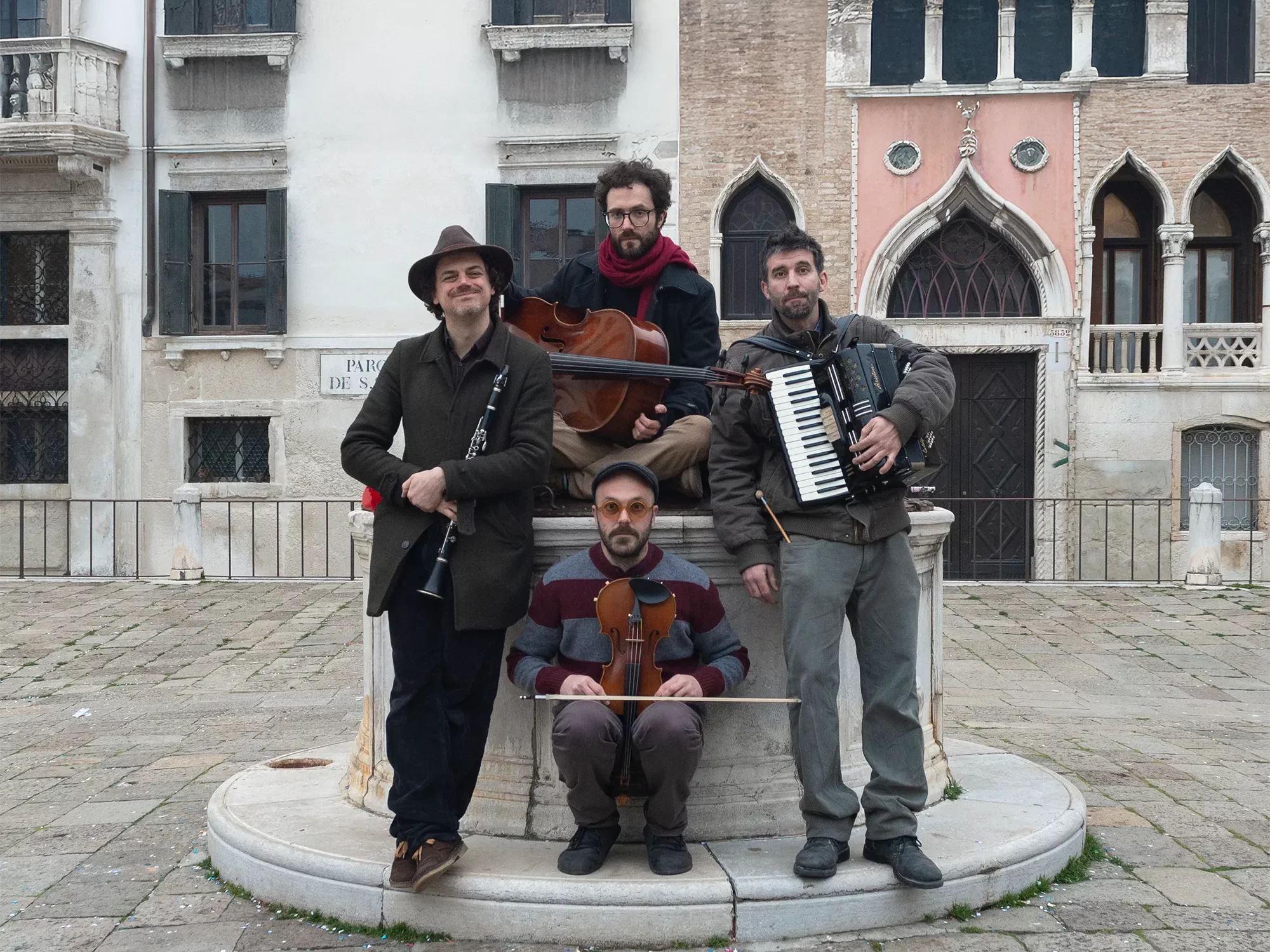 I quattro componenti dei Minimal Klezmer in un campo di Venezia con i loro strumenti musicali